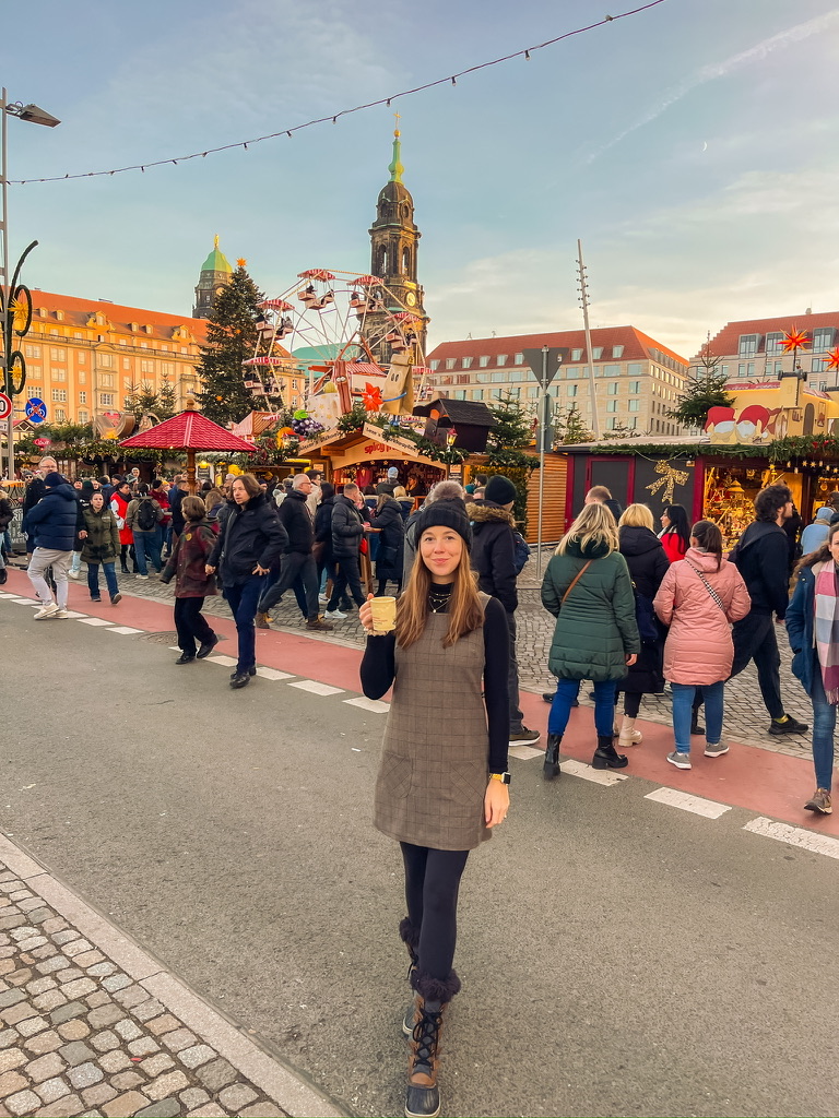 a woman standing in front of a crowd of people at the Dresden Christmas market tip